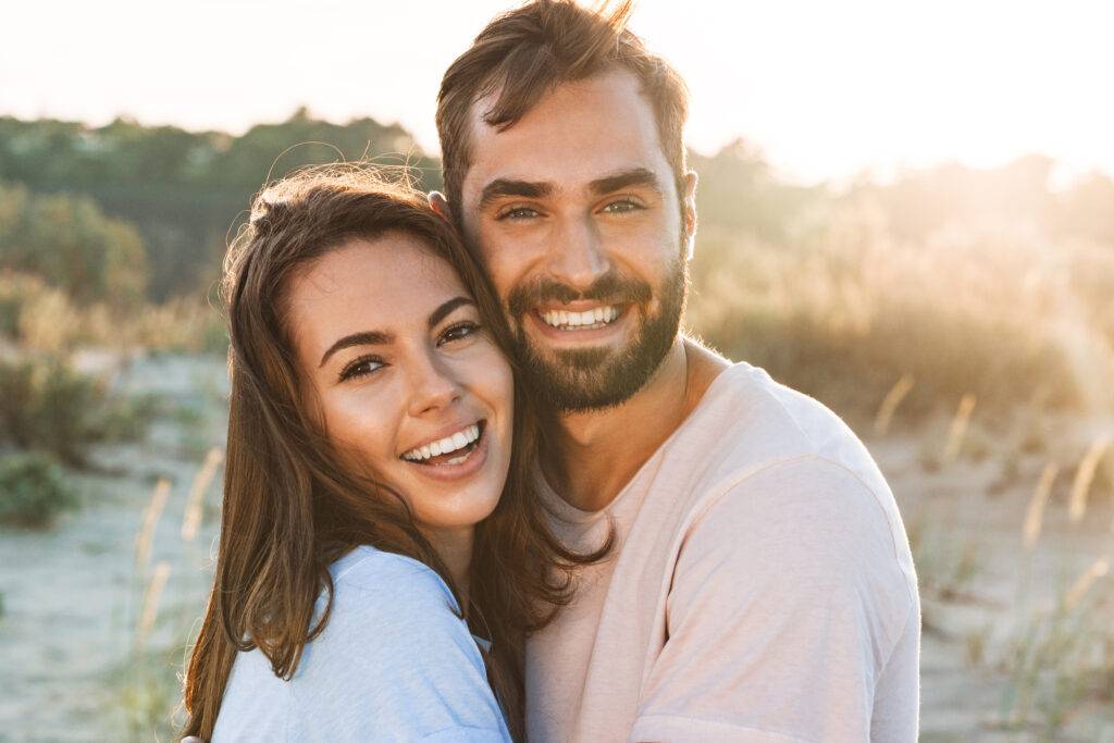 Smiling couple hugging outside