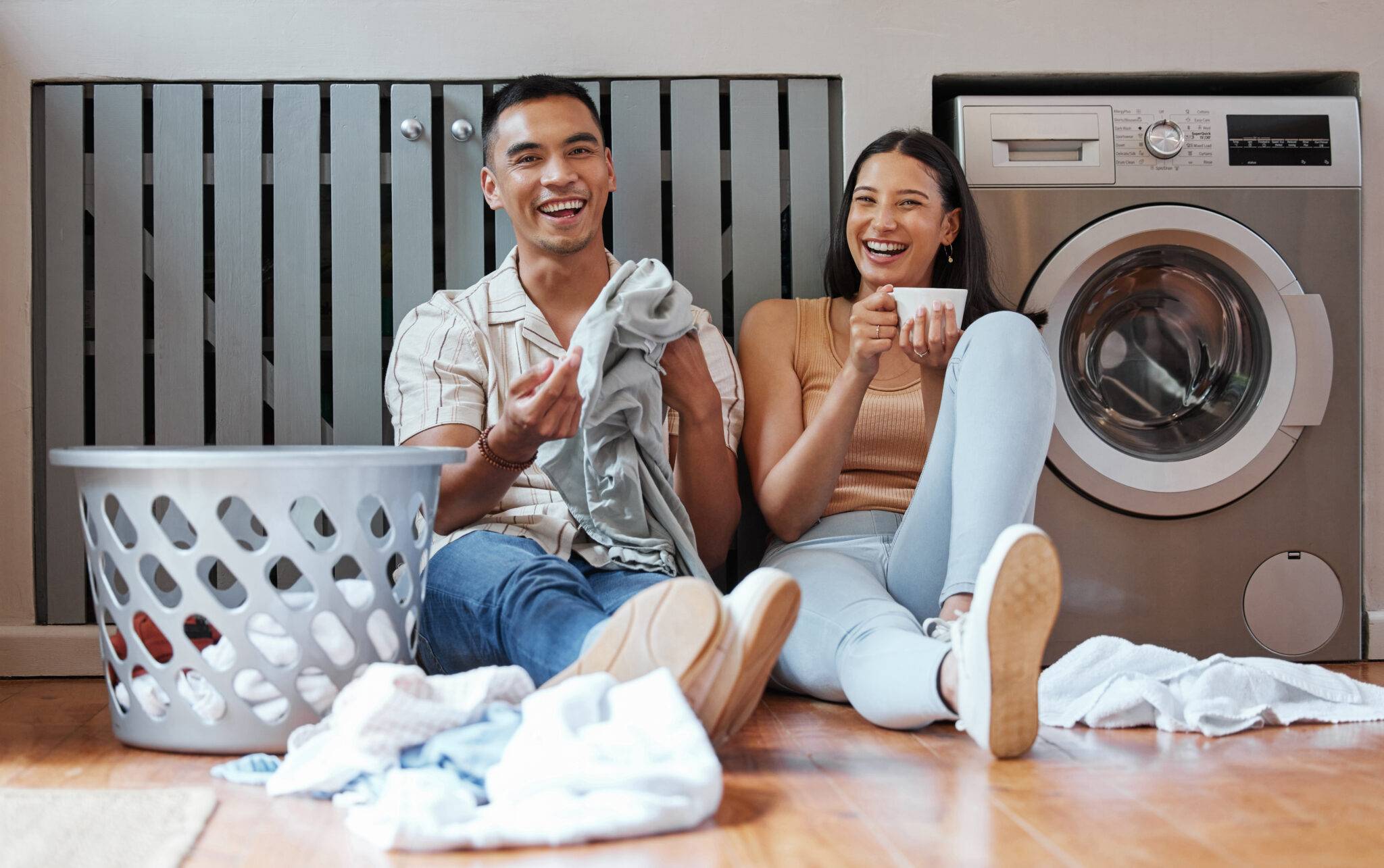 Young couple sitting on the floor folding laundry together