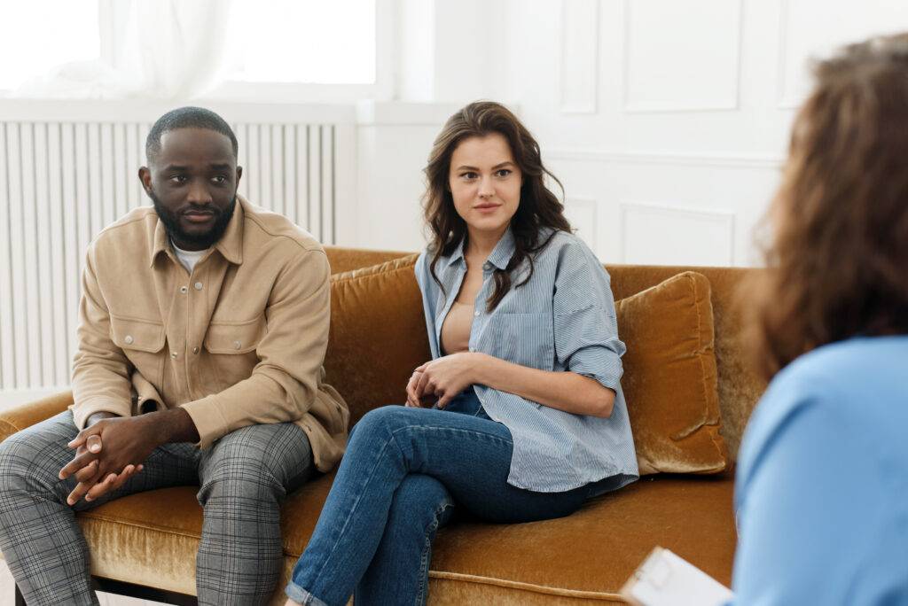 Young couple sitting on couch in couple's therapy session