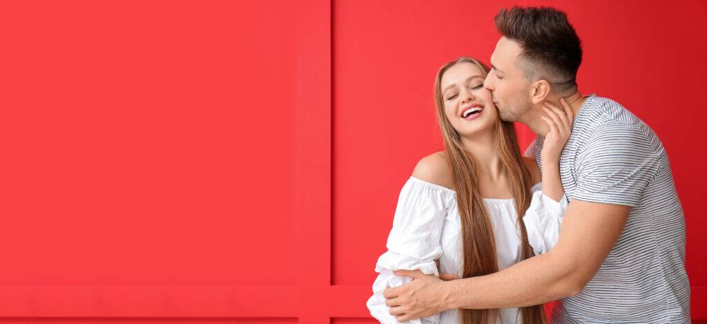 Young couple kissing with red background