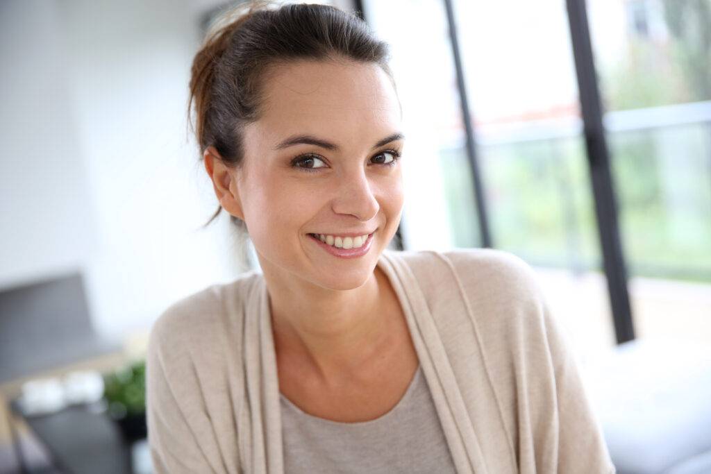 Smiling young woman in her home