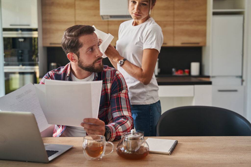 Couple at a table going over paperwork, the man looking serious