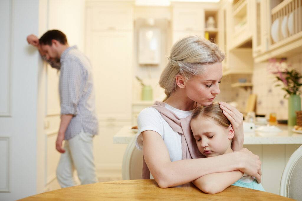 Mother comforting her young child at home