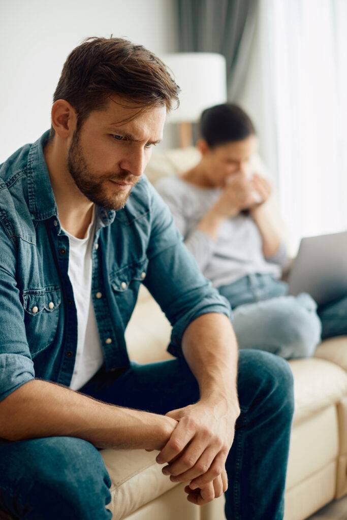 Worried man sitting alone, thinking about problems in his relationship