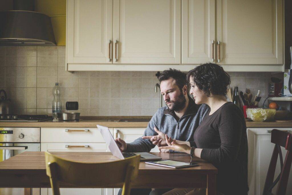 Couple discussing ADHD and marriage communication challenges at a kitchen table.