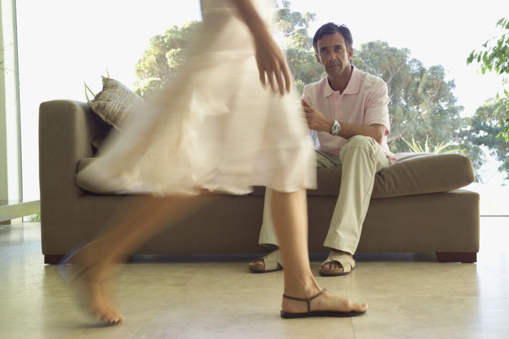 woman-walking-past-man-sitting-on-sofa-2026-03-26-09-10-43-utc • Experience Hope Counseling woman walking past her husband