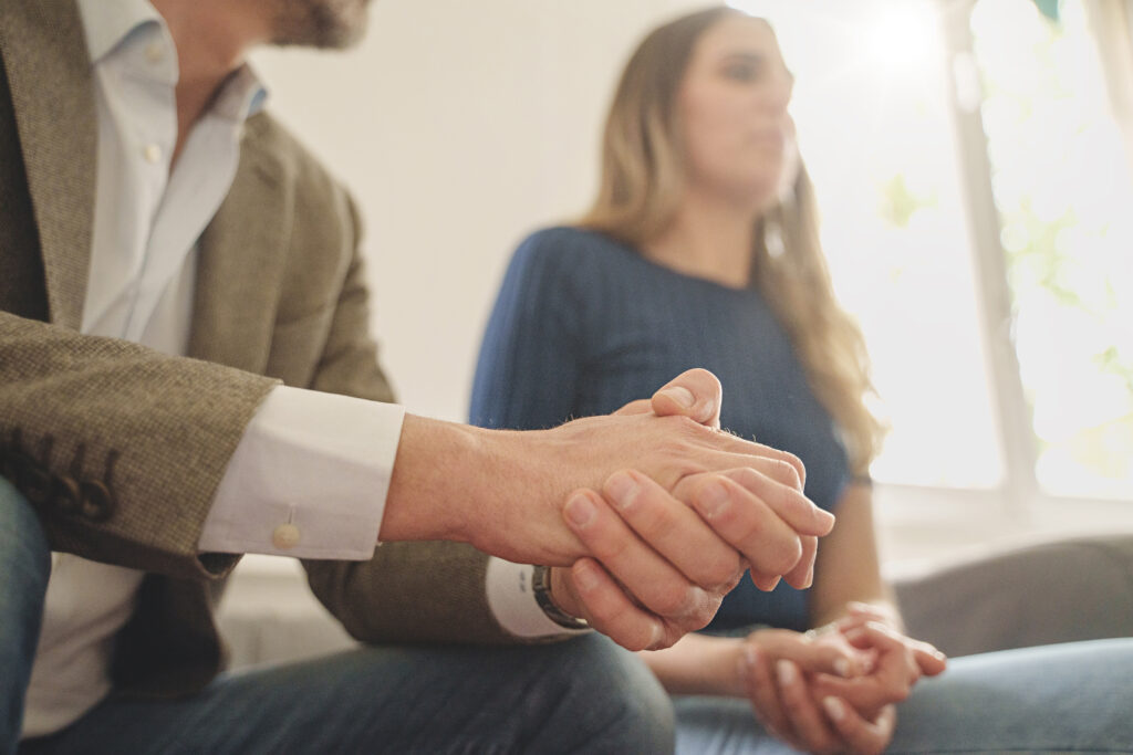 Business colleagues join hands in a show of teamwork and agreement, foreground hands in focus.