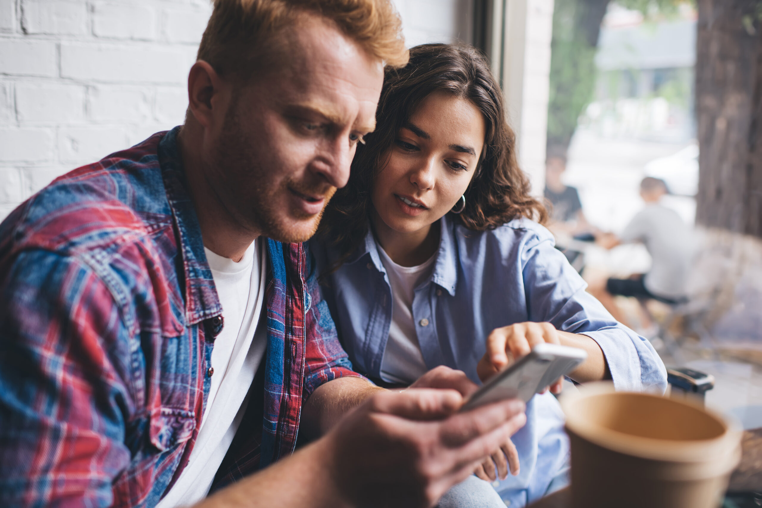 Couple smiling together, looking at a phone