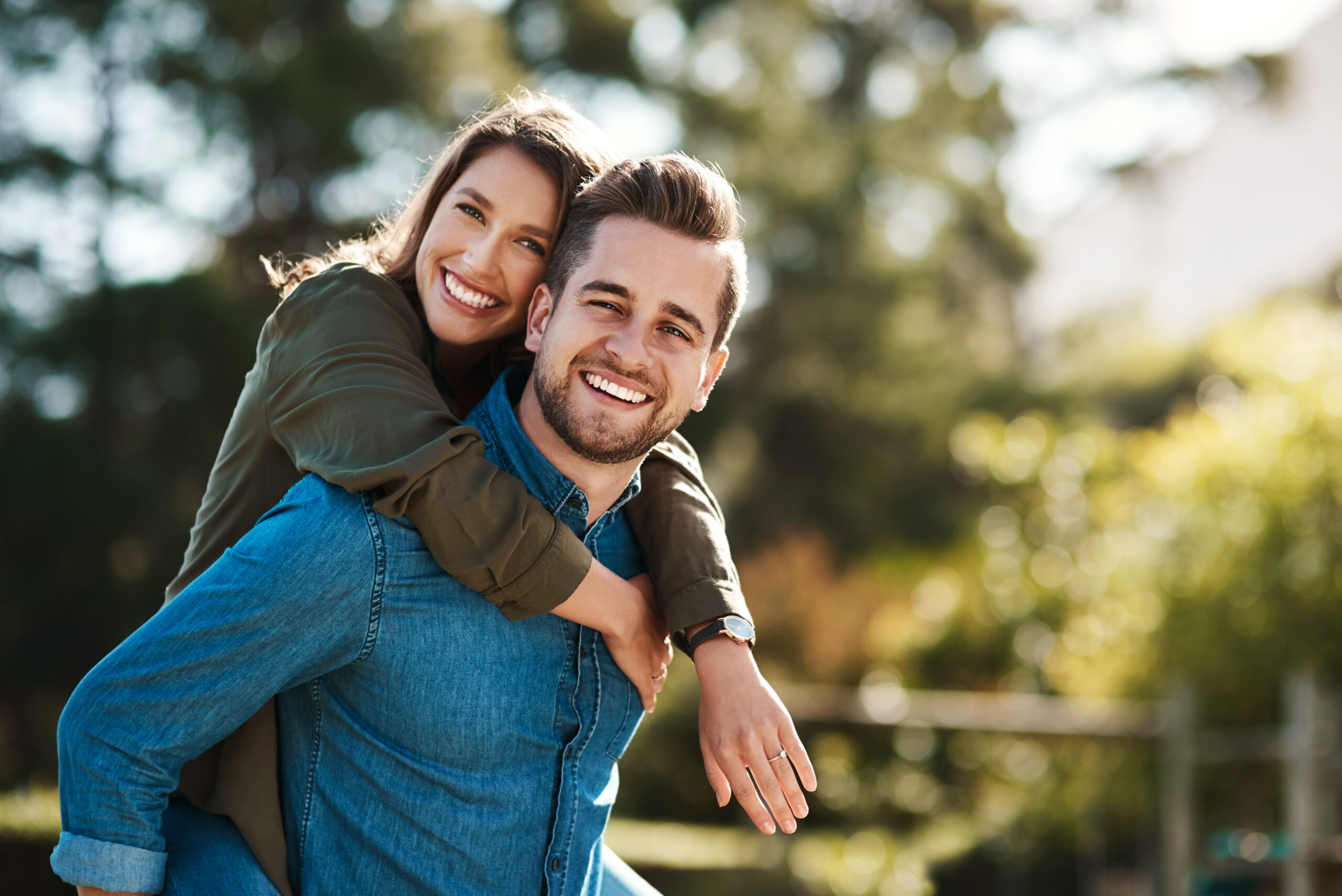 Happy couple enjoying a piggyback ride in the sun